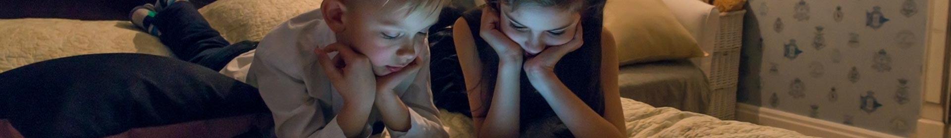 Reading-at-night-2-kids-looking-at-tablet-GettyImages-904890916